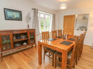 a dining room with a wooden table and chairs at Trederwen in Rhayader