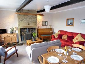 a living room with a red couch and a table at Ginnel Corner in Golcar