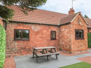 a picnic table in front of a brick building at The Paddock in Wheldrake