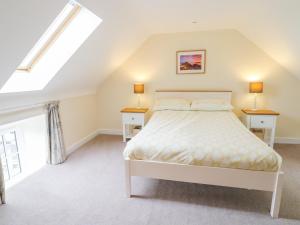 ein Schlafzimmer mit einem Bett und zwei Nachttischen in der Unterkunft Plas Tirion Cottage in Mostyn