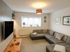 a living room with a couch and a tv at Belgrave House in Mickleton