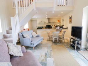 a living room with a couch and a tv and a table at Plas Tirion Cottage in Mostyn