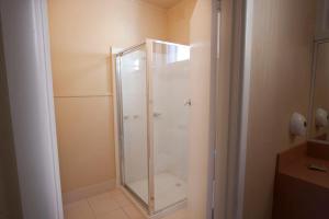 a shower with a glass door in a bathroom at Parkville Motel in Melbourne