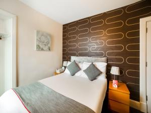 Un dormitorio con una cama grande y una pared en OYO Braeriach Hotel, Highlands Scotland, en Newtonmore