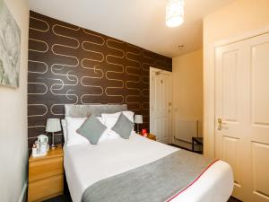 a bedroom with a bed with a black accent wall at OYO Braeriach Hotel, Highlands Scotland in Newtonmore