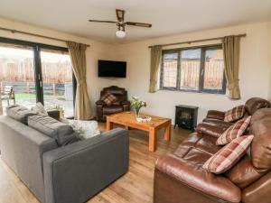 a living room with two couches and a table at Caban Nant Ddu in Nantmel