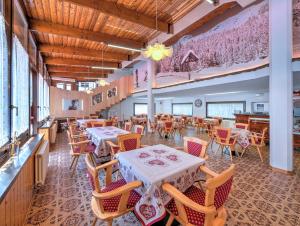 a restaurant with tables and chairs in a room at Hotel Kapriol in Folgarida