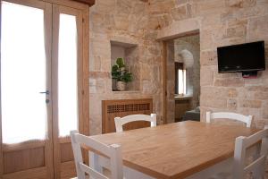 una sala da pranzo con tavolo e sedie in legno di Trulli Loco a Locorotondo