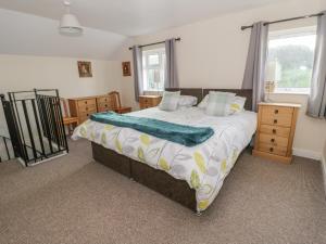 a bedroom with a large bed and a window at Glan Y Gors Cottage in Llangerniew