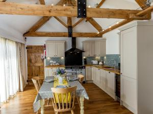 a kitchen with a table and chairs in a room at Oxen Cottage Nables Farm in Seagry