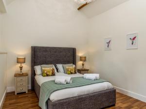 a bedroom with a large bed with two night stands at Oxen Cottage Nables Farm in Seagry
