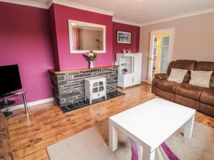 a living room with a couch and a fireplace at Ardwyn in Bala
