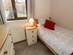 a small bedroom with a bed and a lamp on a night stand at Ardwyn in Bala