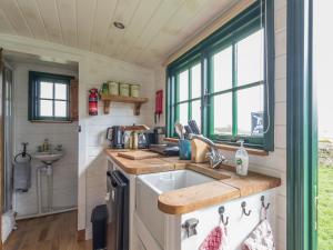 - une cuisine dans une petite maison avec évier dans l'établissement Peat Gate Shepherd's Hut, à Greenhead