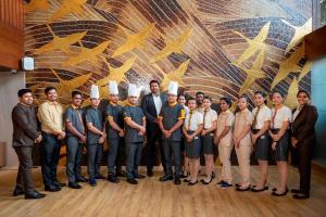 a group of people posing for a picture in front of a wall at Yu Hotel, Candolim in Candolim