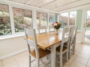 a dining room with a table and chairs and windows at Ardwyn in Bala