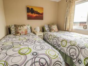 Duas camas sentadas uma ao lado da outra num quarto em Little Gem Lodge em Saint Boswells