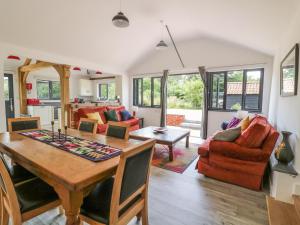 a dining room and living room with a table and chairs at Whitehands Farm Barn in Old Buckenham