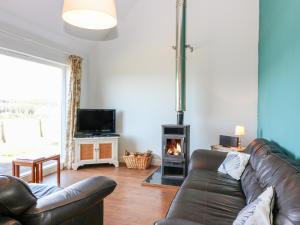 a living room with a couch and a fireplace at Poppies Cottage in Craignure