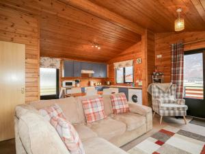 a living room with a couch and a kitchen at Wildcat Lodge in Etteridge