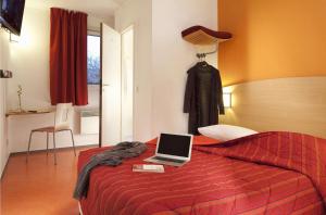 A bed or beds in a room at Premiere Classe Les Ulis - Courtaboeuf