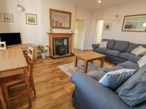 a living room with a couch and a table at Drumbuie in Kirkbean