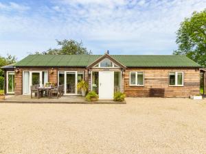 uma pequena casa de madeira com um telhado verde em Newton Retreat em North Charlton