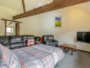 a bedroom with a bed and a flat screen tv at Duckling Barn in Bacton