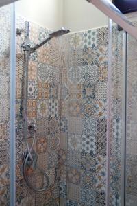 een douche in de badkamer met tegels op de muur bij B&B La La Rose in Piedimonte San Germano