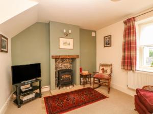 a living room with a tv and a fireplace at Brookside Barn in Bradwell