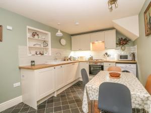 a kitchen with a table and a table and chairs at Brookside Barn in Bradwell