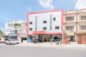 a building on a street with cars parked in front of it at OYO 2552 Hotel Permata in Makassar