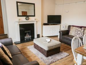 a living room with a couch and a fireplace at Worth Valley Cottage in Haworth