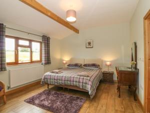 a bedroom with a bed and a desk and a window at Caer Moel in Llanwnda