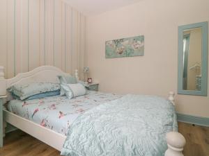 una camera con letto bianco e specchio di Worth Valley Cottage a Haworth