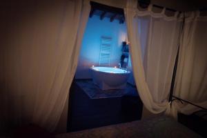 a bathroom with a tub in a room with curtains at La Morada del Druida in Los Narros