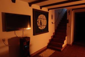 a living room with a television and a staircase at La Morada del Druida in Los Narros