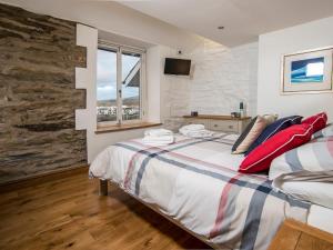 a bedroom with a bed with red pillows on it at The Captain's Penthouse in Porthmadog