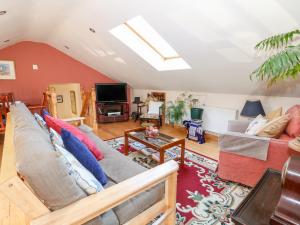 a living room with a couch and a tv at Berry Barn in Strubby