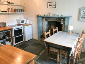 a kitchen with a table and a kitchen with a fireplace at Half of 6 in The Braes