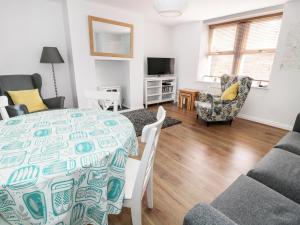a dining room and living room with a table and chairs at Sunnie Cottage in Seahouses