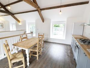 una cucina e una sala da pranzo con tavolo e sedie in legno di Cefn Bryn Mawr a Criccieth