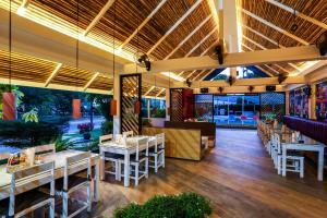 un restaurant avec des tables et des chaises dans une salle dans l'établissement Naiharn Beach Resort - SHA Plus Extra, à Nai Harn Beach