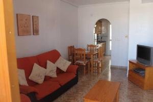 salon z czerwoną kanapą i stołem w obiekcie La Ciñuelica R15 1st Floor Apartment Com Pool L164 w mieście Orihuela