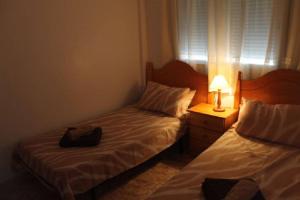 sypialnia z 2 łóżkami i lampką na stoliku nocnym w obiekcie La Ciñuelica R15 1st Floor Apartment Com Pool L164 w mieście Orihuela +8 zdjęć