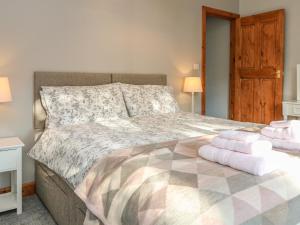 a bedroom with a bed with two towels on it at Lees Cottage in Bradwell