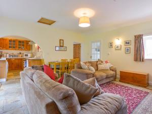 a living room with two couches and a kitchen at Goslings in Thornbury