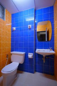 bagno piastrellato blu con servizi igienici e lavandino di Vintage Studio Apartment Thonglor Ekkamai a Ban Na Song