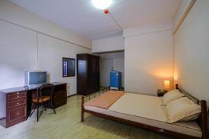 una camera con letto, scrivania e TV di Vintage Studio Apartment Thonglor Ekkamai a Ban Na Song