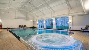 a large swimming pool with a hot tub at Leonardo Hotel Cheltenham in Cheltenham